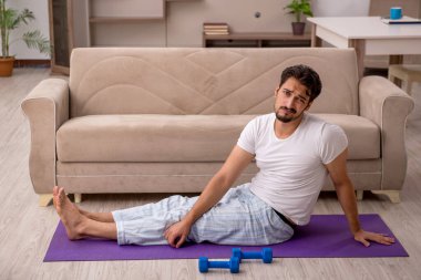 Genç adam evde spor yapıyor.