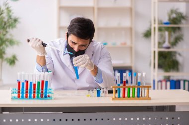 Salgın sırasında laboratuvarda çalışan genç bir kimyager.