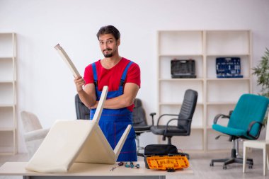 Genç erkek marangoz atölyede çalışıyor.