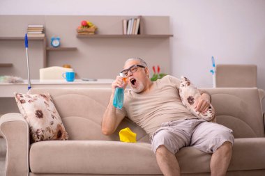 Yaşlı adam evde ev işi yapıyor.