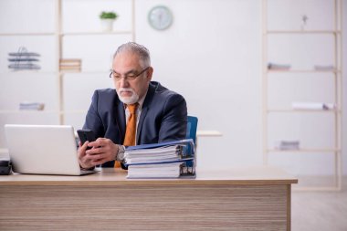 Ofiste çalışan yaşlı bir erkek işçi.