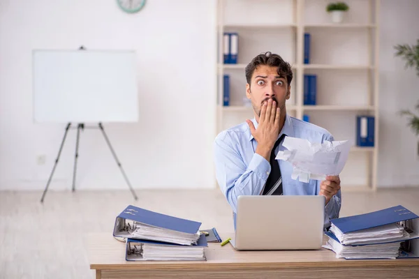 Jovem funcionário masculino infeliz com excesso de trabalho no escritório — Fotografia de Stock