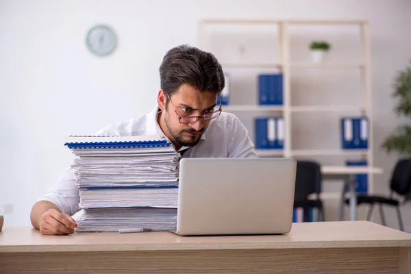 Joven empleado masculino descontento con el trabajo excesivo en la oficina — Foto de Stock