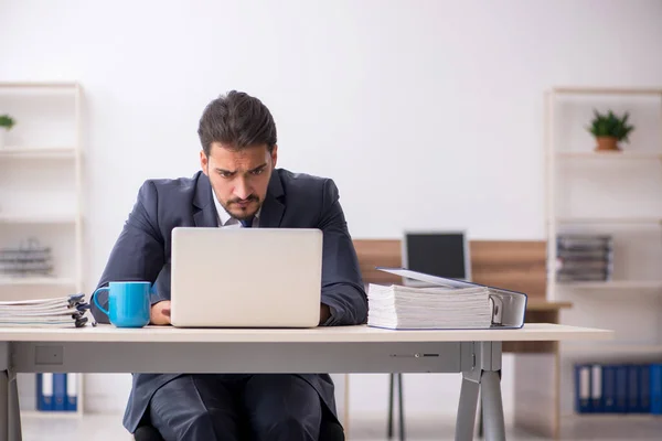 Junge männliche Mitarbeiter sitzen am Arbeitsplatz — Stockfoto