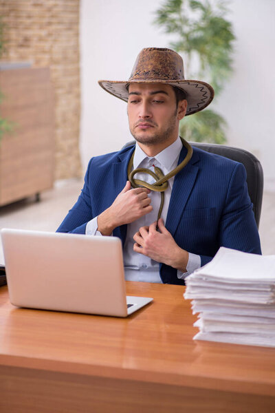 Young cowboy businessman working at workplace