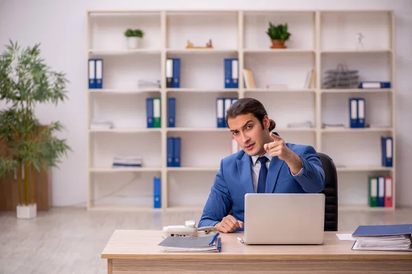 Joven empleado masculino sentado en la oficina — Foto de Stock