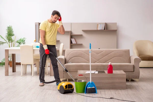 Genç erkek müteahhit evi temizliyor.