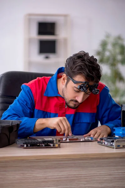 Bilgisayar tamir eden genç bir erkek tamirci.