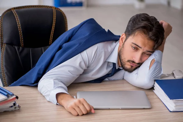 Genç erkek çalışan ofiste çok yorgun.