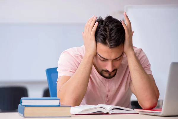 Joven estudiante masculino preparándose para los exámenes en el aula — Foto de Stock