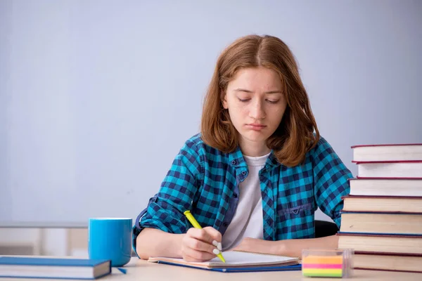 Ung kvinnlig student förbereder sig för tentor i klassrummet — Stockfoto