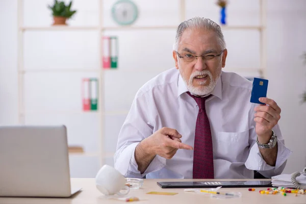 Old drug addicted employee sitting in the office — Stock Photo, Image