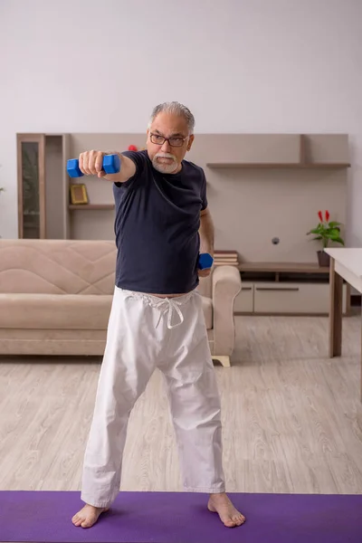 Yaşlı adam evde spor yapıyor. — Stok fotoğraf
