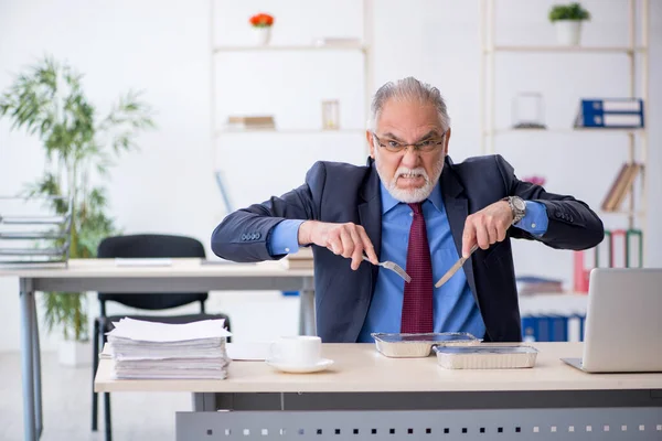 Vecchio dipendente maschio che fa colazione in ufficio — Foto Stock