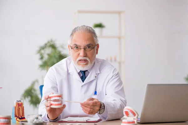 Old male doctor dentist working in the clinic — Stock Photo, Image