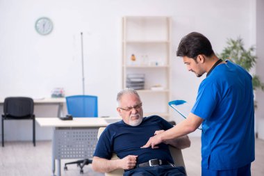 Yaşlı adam genç erkek doktoru ziyaret ediyor.