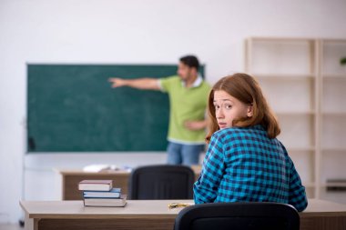 Genç öğretmen ve öğrenci sınıfta.