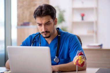 Klinikte çalışan genç erkek doktor.