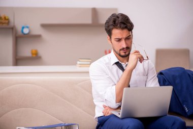 Genç erkek çalışan salgın sırasında evden çalışıyor.