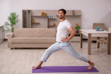 Genç adam evde spor yapıyor.