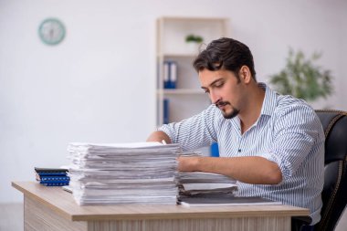 Ofisteki aşırı işten memnun olmayan genç bir erkek işçi.