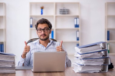 Ofisteki aşırı işten memnun olmayan genç bir erkek işçi.