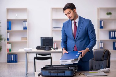 Genç bir erkek işçi iş yerinde geziye hazırlanıyor.