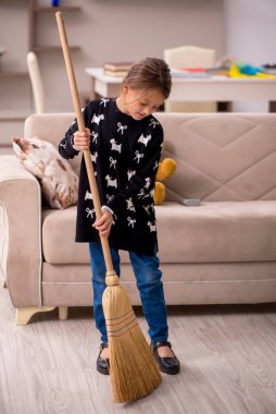 Küçük kız evde ev işi yapıyor.
