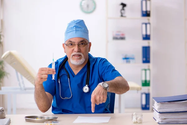Velho médico do sexo masculino trabalhando na clínica — Fotografia de Stock