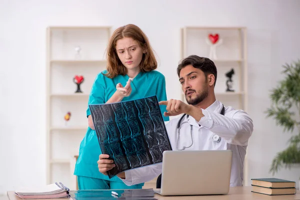 Ung manlig läkare radiolog och kvinnlig assistent arbetar i th — Stockfoto