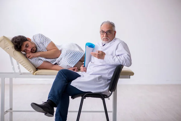 Old male doctor psychiatrist examining young male patient