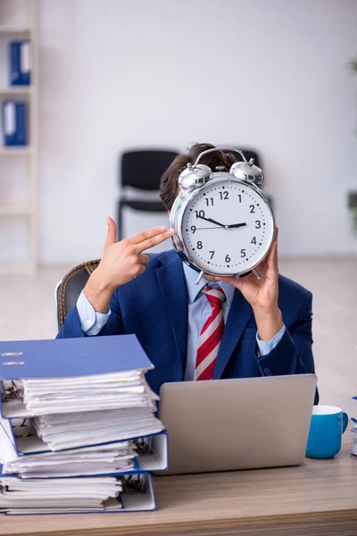 Joven empleado masculino en concepto de gestión del tiempo — Foto de Stock