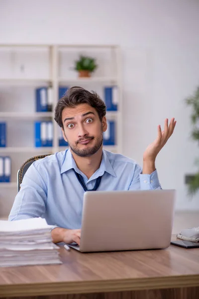 Giovane dipendente maschio e troppo lavoro in ufficio — Foto Stock