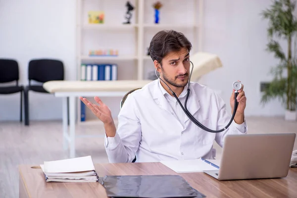 Ung manlig läkare som arbetar på kliniken — Stockfoto