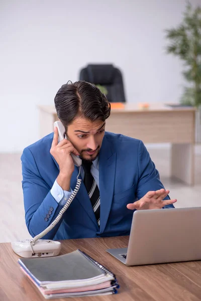 Jeune employé masculin mécontent du travail excessif au bureau — Photo