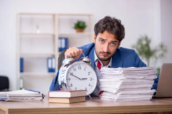 Joven empleado masculino en concepto de gestión del tiempo — Foto de Stock