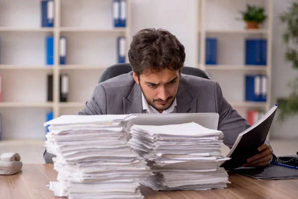 Joven empleado masculino descontento con el trabajo excesivo en la oficina — Foto de Stock