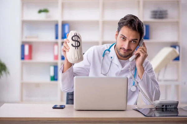 Jonge mannelijke arts werkzaam in de kliniek — Stockfoto