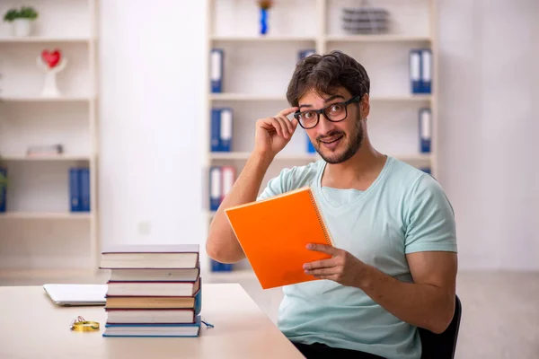 Ung manlig student förbereder sig för tentor i klassrummet — Stockfoto