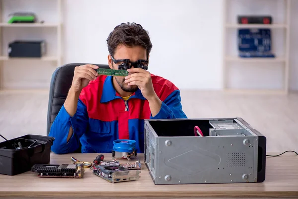 Bilgisayar tamir eden genç bir erkek tamirci.
