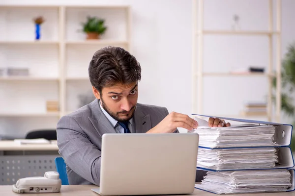 Junge männliche Mitarbeiter und zu viel Arbeit im Büro — Stockfoto