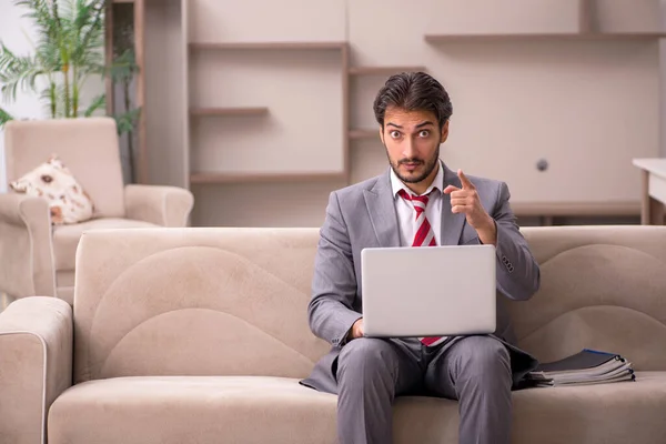 Ung manlig anställd som arbetar hemifrån under en pandemi — Stockfoto