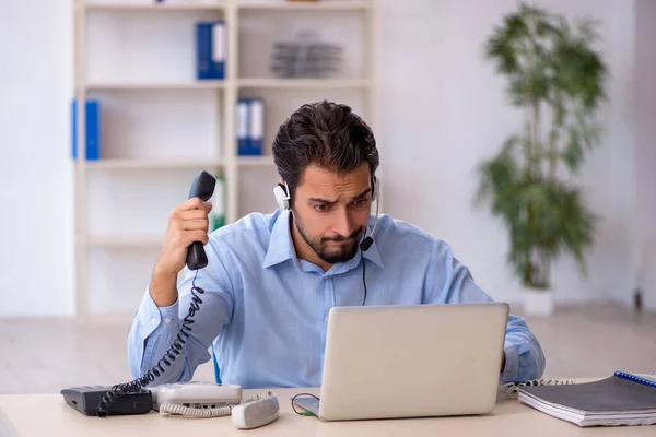 Young male call center operator working at his desk — Stock Photo, Image