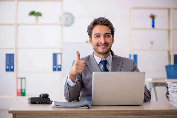 Empleado joven sentado en el lugar de trabajo — Foto de Stock