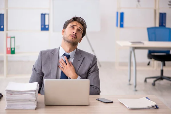 Jovem trabalhador masculino sentado no local de trabalho — Fotografia de Stock