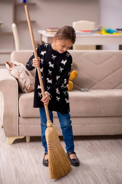 Küçük kız evde ev işi yapıyor.