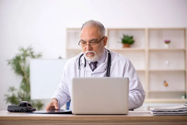 Klinikte çalışan yaşlı bir erkek radyolog. — Stok fotoğraf