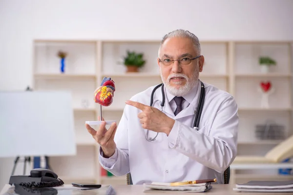 Klinikte çalışan yaşlı bir erkek kardiyolog. — Stok fotoğraf