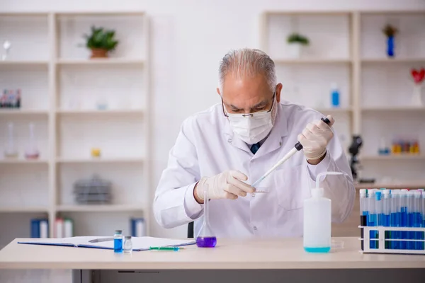 Oude mannelijke chemicus werkt in het lab. — Stockfoto