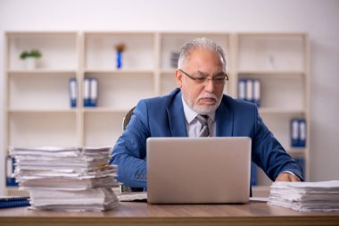 Ofiste çalışan yaşlı bir erkek.